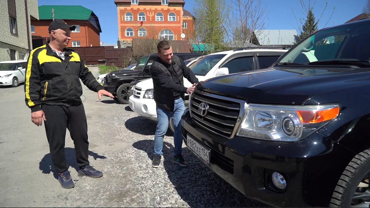 Дмитрий Воронько осматривает Toyota Land Cruiser 200 рядом с ведущим Garage 54